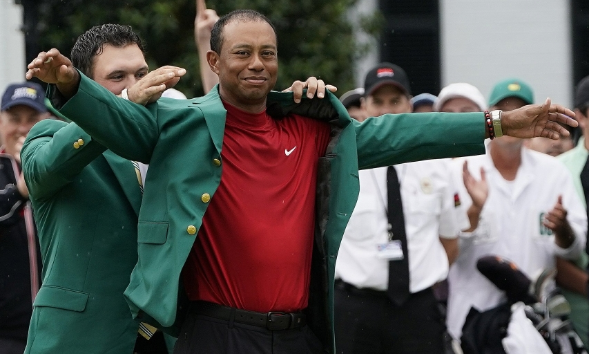 Patrick Reed helps Tiger Woods with his green jacket